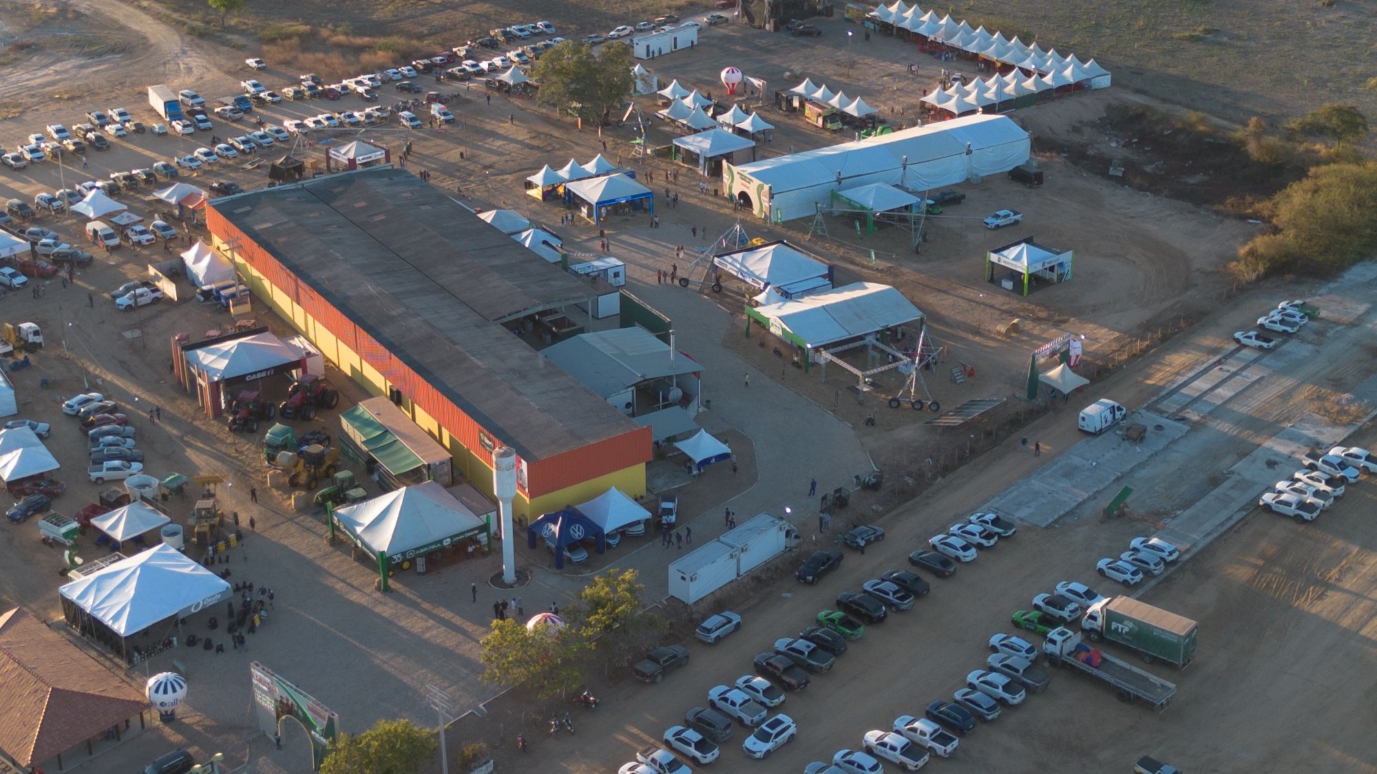 Pavilhão principal de uma feira do agronegócio com máquinas agrícolas expostas ao redor